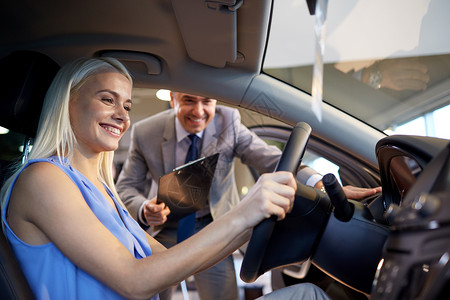 在汽车展或沙龙的汽车经销商驾驶消费者司机服务销售女士快乐顾客讲师男人背景图片