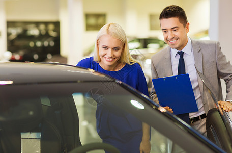在汽车展或沙龙的汽车经销商销售女士测试服务微笑女孩顾客男人人士商务背景图片