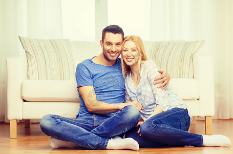 在家微笑的一对快乐的情侣长椅女士夫妻沙发房子女性地毯家庭幸福男性迷人的高清图片素材