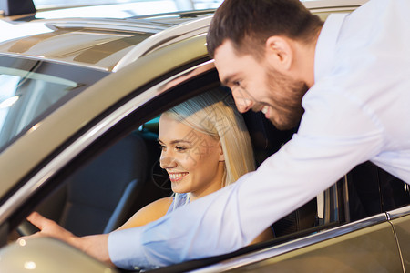快乐的情侣在汽车展或沙龙买车车辆顾客经理男人司机微笑拉丁服务运输妻子背景图片