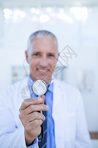 快乐的医生对着镜头微笑 展示他的听诊器护士男人工作服从业者男性服务保健专业医疗诊所专业职业高清图片素材