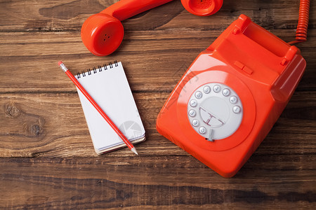 带有注纸的桌上电话讯息桌子记事本拨号铅笔固定电话橡木红色木头沟通背景图片