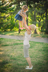 在户外带婴儿的母亲孩子女士幸福草地童年快乐父母喜悦公园闲暇可爱的高清图片素材