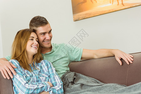 情侣在沙发上放松客厅房子闲暇男性服装拥抱住所男人家庭长椅背景图片