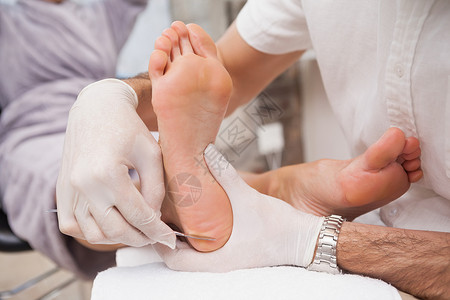 使用手术刀的沙龙工人修脚美甲按摩修脚师工作指甲足部中心死皮奢华背景图片