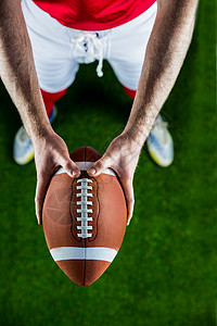 美国足球运动员举起橄榄球赛事竞技四分卫体育双手运动草坪力量天文男性活动背景图片