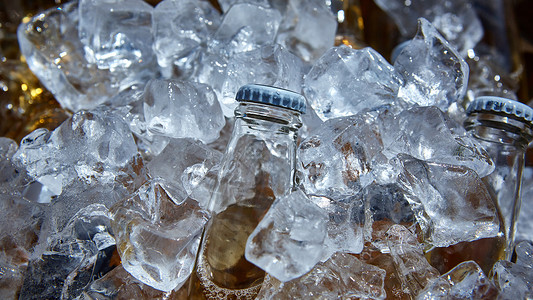 瓶啤酒在冰冰中玻璃强光瓶子泡沫广告生活娱乐立方体酒吧金子背景图片