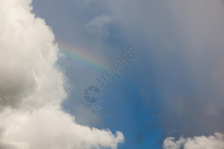 雨季的云和彩虹光轮背景图片