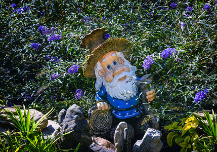花中侏儒的雕像很有意思帽子快乐花园情绪设计人员工作季节塑像花朵背景图片