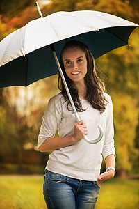拥有伞状的年轻妇女幸福公园季节女性成人背景