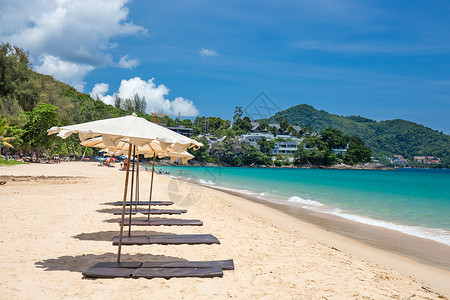 蓝天海滩上沙滩上的海滨雨伞旅行娱乐日光浴天堂热带太阳蓝色旅游晴天假期背景图片