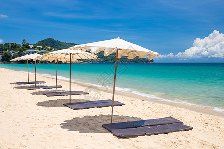 蓝天海滩上沙滩上的海滨雨伞阴影天空海岸娱乐晴天海洋蓝色阳光太阳日光浴背景图片