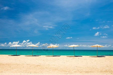 蓝天海滩上沙滩上的海滨雨伞地平线天空娱乐阳光海浪支撑蓝色太阳晴天天堂背景图片