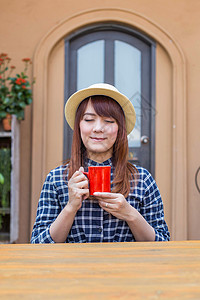 穿着帽子的女士坐在户外 喝热饮放松咖啡女孩食物饮料黑发杯子咖啡店巧克力女性香气可口高清图片素材