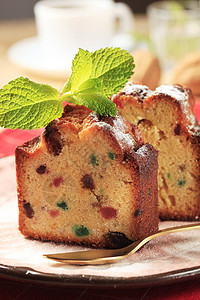 水果蛋糕切片盘子横截面甜点早餐薄荷小吃葡萄干水果蛋糕干果树叶背景图片