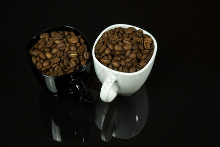 两个杯子装满咖啡豆 黑色背景的黑底背景图片