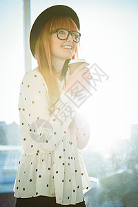 喝咖啡的女士笑得不高兴外带毡帽边缘咖啡红发微笑眼镜咖啡杯窗户休闲背景图片