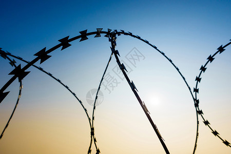Razor 铁丝网金属太阳俘虏障碍天空囚犯剃刀监狱边界拉伸背景图片