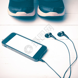 运动鞋和电话老旧风格木头手表运动技术跑步耳机音乐健身房手机毛巾背景图片