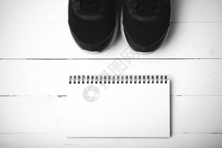 正在运行鞋子和笔记纸黑白音调颜色样式健身房饮食运动锻炼记事本笔记本木头白色瓶子竞赛背景图片