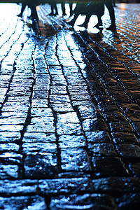 夜间湿铺卵石铺路石头街道岩石城市鹅卵石行人背景图片