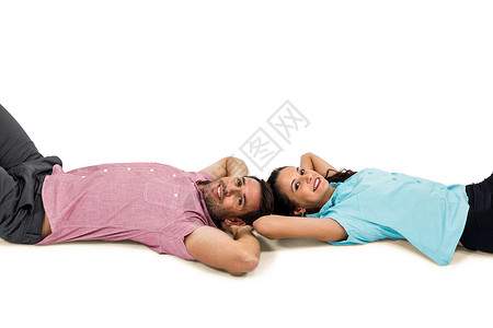一对微笑的夫妇躺在地板上 双手放在头上异性高清图片素材