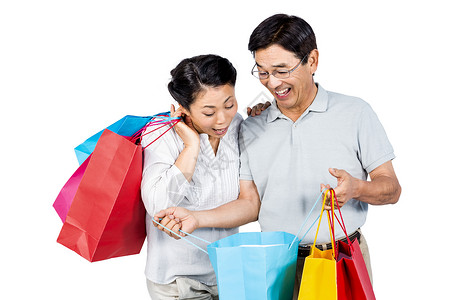 带购物袋的老年夫妻礼物采购感情金发零售男性快乐女士金发女郎微笑背景图片