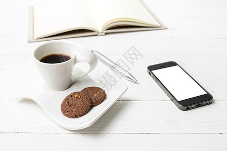 咖啡杯加饼干 手机用笔记本和笔咖啡工作钥匙网络电话杯子眼镜办公室桌子细胞背景图片