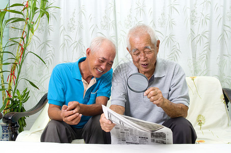 亚洲家庭老年儿子退休快乐阅读报纸男性闲暇男人长老背景图片