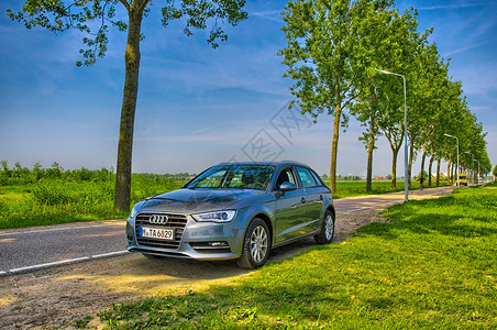 奥迪A3荷兰阿姆斯特丹  2013 年 6 月 银色奥迪 A3 在路上农村发动机国家蓝色野餐掀背车旅行草地引擎日落背景