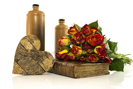 粉红玫瑰花束瓶装有旧书和红玫瑰的石头瓶背景