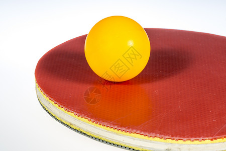 台式网球和板球黑色乒乓球拍橙子运动宏观灰色红色背景图片