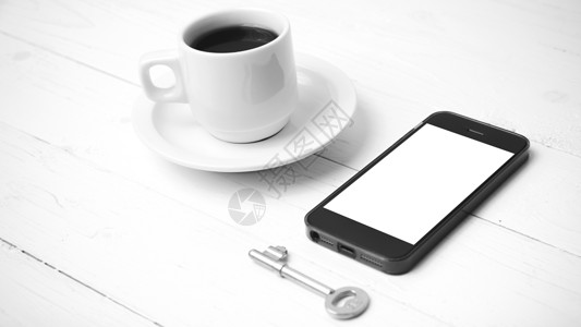配有电话和黑白主要颜色的咖啡杯办公室细胞咖啡钥匙网络工作笔记本眼镜杯子桌子背景图片