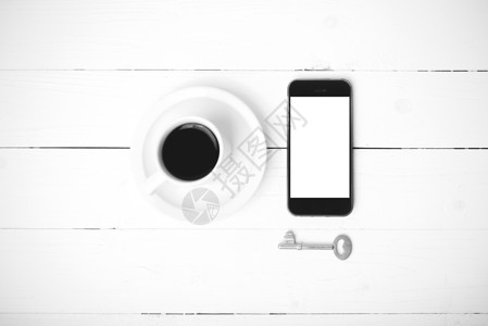配有电话和黑白主要颜色的咖啡杯杯子咖啡笔记本工作钥匙桌子细胞办公室网络眼镜背景图片