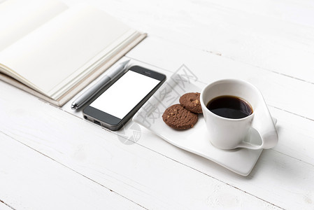 咖啡杯加饼干 手机用笔记本和笔桌子杯子细胞网络办公室电话眼镜咖啡钥匙工作背景图片