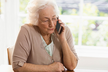微笑的年长妇女打电话住所技术桌子呼唤闲暇电话女士沟通流金手机背景图片