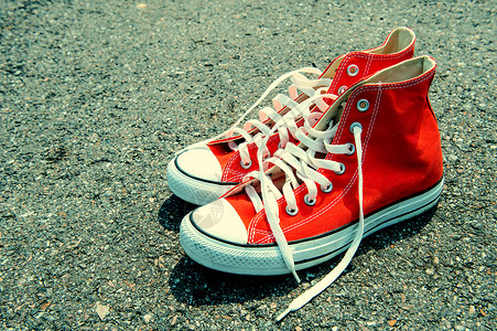 黑色背景的红运动鞋 旧颜色背景图片