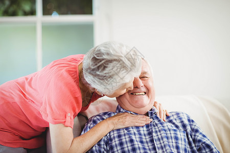 高贵的女子在脸颊上亲吻男人喜悦休闲服装公寓拥抱头发感情住所夫妻退休老年高清图片素材