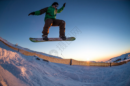 在山上滑雪套装木板杂技假期日落男生男人美化多云滑雪板背景图片