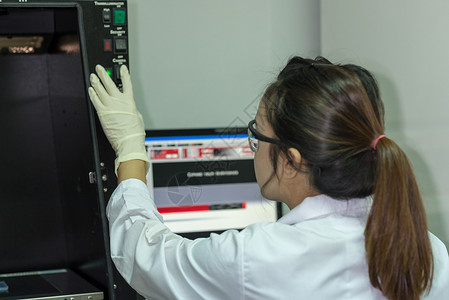 在分子生物学实验室工作的女技术员 妇女技术员检测测试化学科学电泳指纹药品生物学遗传染料背景