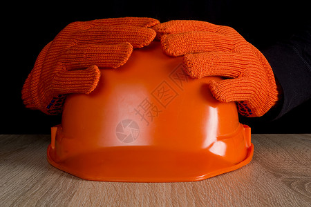 安全掌握在手中橙色建筑头盔掌握在手中商业衣服工作帽子男性危险职业安全帽工业工具背景