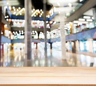 在模糊商场前面的木板空桌架子台面大厅桌子推介会商业建筑零售贸易产品背景图片