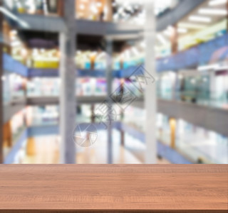 在模糊商场前面的木板空桌架子建筑商业中心剪辑柜台嘲笑部门桌子台面背景图片