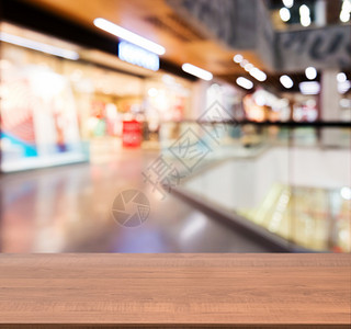 在模糊商场前面的木板空桌背景购物中心木头中心台面走廊商业店铺展示架子背景图片