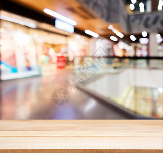 在模糊商场前面的木板空桌木头展示商品部门中心购物中心背景台面桌子产品背景图片