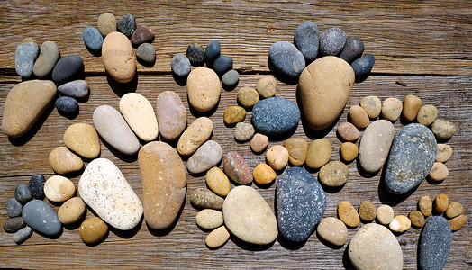 抽象的可爱小石头 来自巨石的足迹鹅卵石背景卵石黑色背景图片