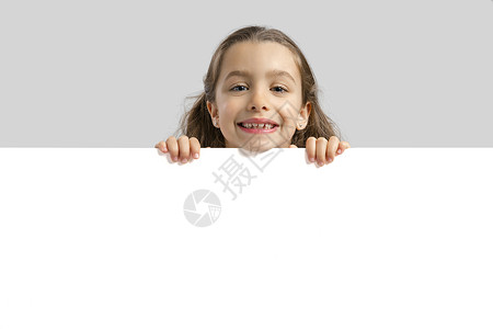 拿着空白板的可爱女孩纸板儿童快乐学生幸福喜悦微笑广告工作室孩子们背景图片