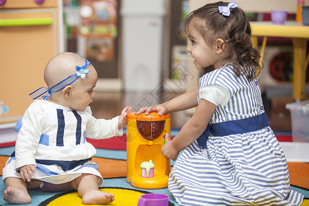 两个小女孩在玩玩具厨房的游戏游戏室咖啡机女孩们背景图片