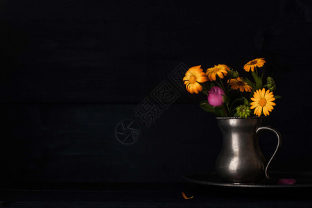 旧金属罐中的花束花粉色水壶投手叶子花瓶香气投标水平黑色托盘背景图片