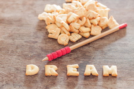 梦想历险记字体木制桌上的梦想字母饼干谷物小吃金子小麦食物午餐框架公司甜点英语背景
